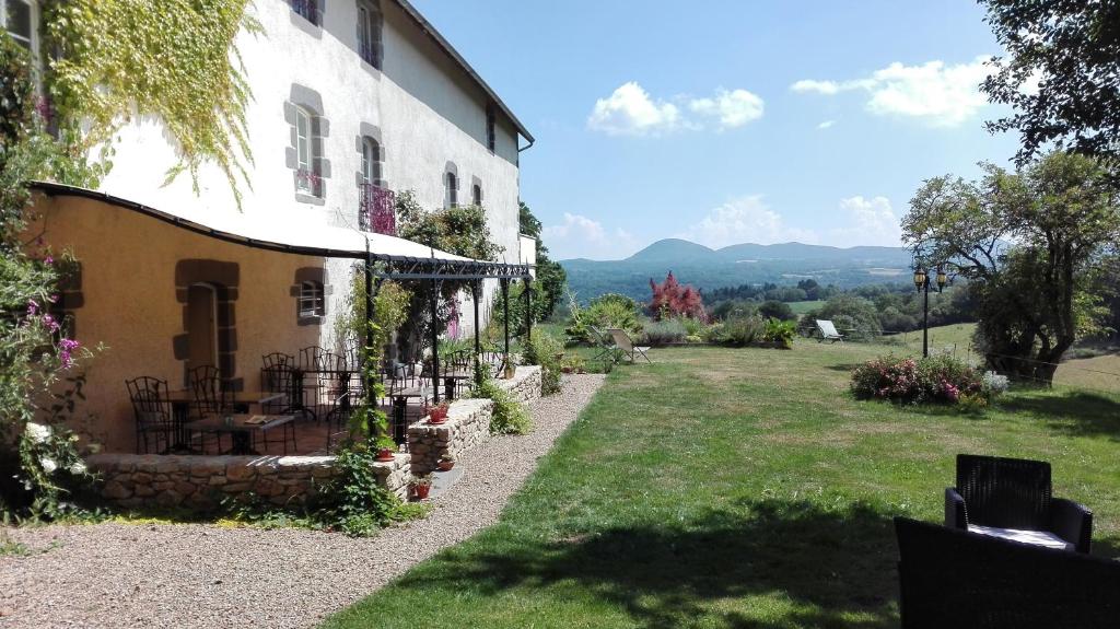 - une vue sur une maison avec une cour dans l'établissement Gîte Le Pré du Roc, à Bromont-Lamothe