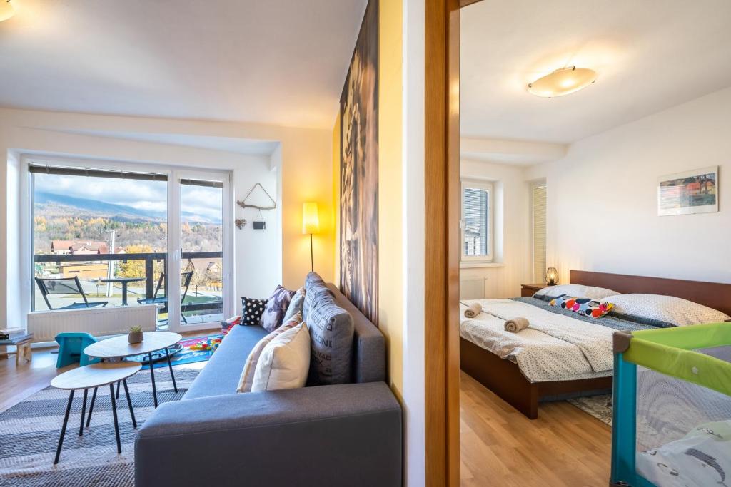 um quarto com um sofá e uma cama num quarto em Apartment Romana High Tatras-Fantastic views-Washer em Nová Lesná