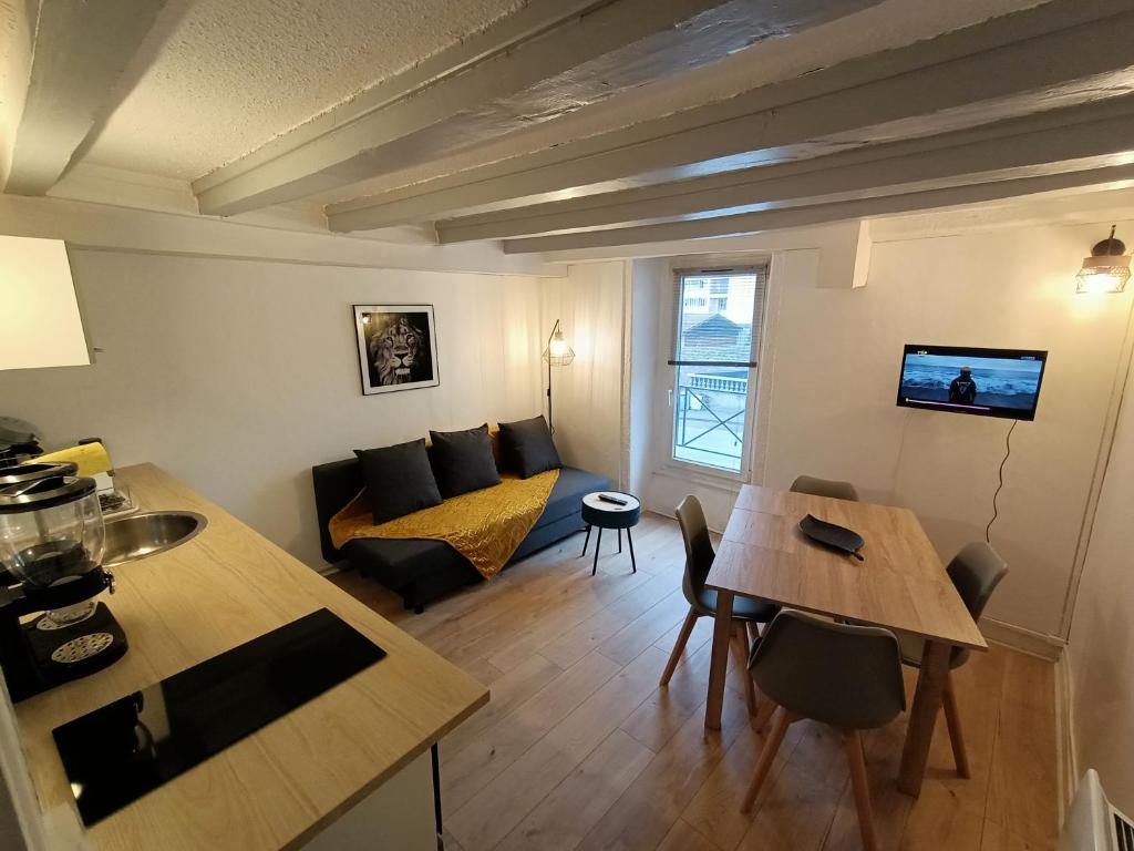 a living room with a couch and a table at Cosy T2 in Montbrison