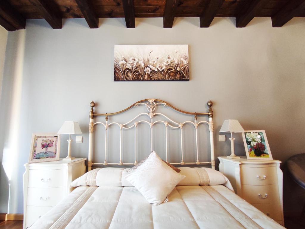 a bedroom with a bed and two night stands at Del Abuelo Casa Rural in Prádena del Rincón