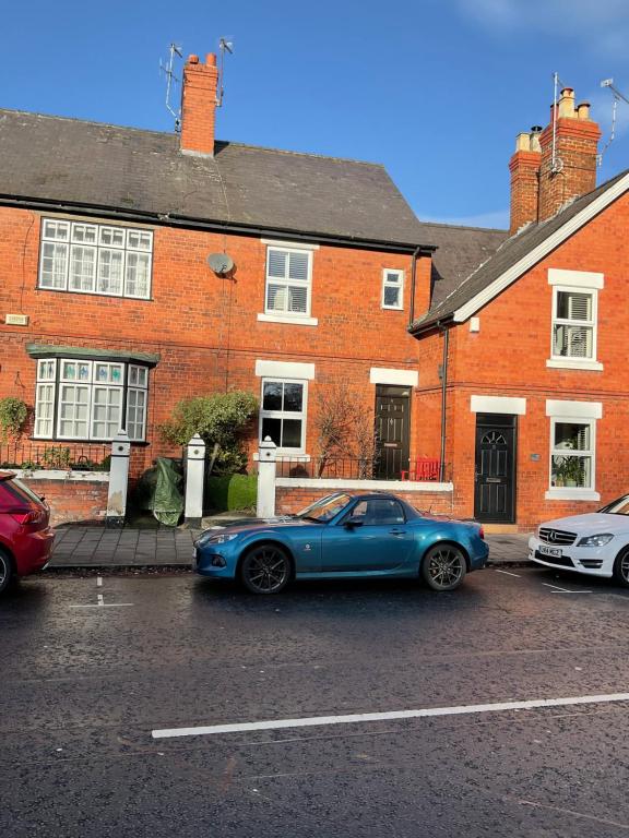 un coche azul estacionado frente a una casa de ladrillo en Park View, en Chester