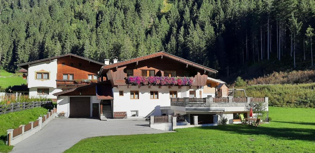 a house with a balcony with flowers on it at Landhaus Volderau in Neustift im Stubaital