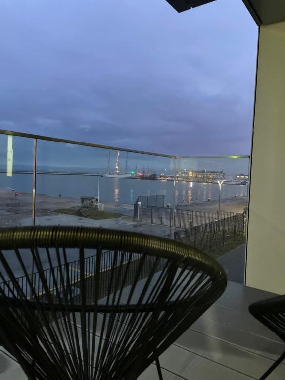 een bank op een balkon met uitzicht op het strand bij Śledź Gdynia - YACHT PARK in Gdynia