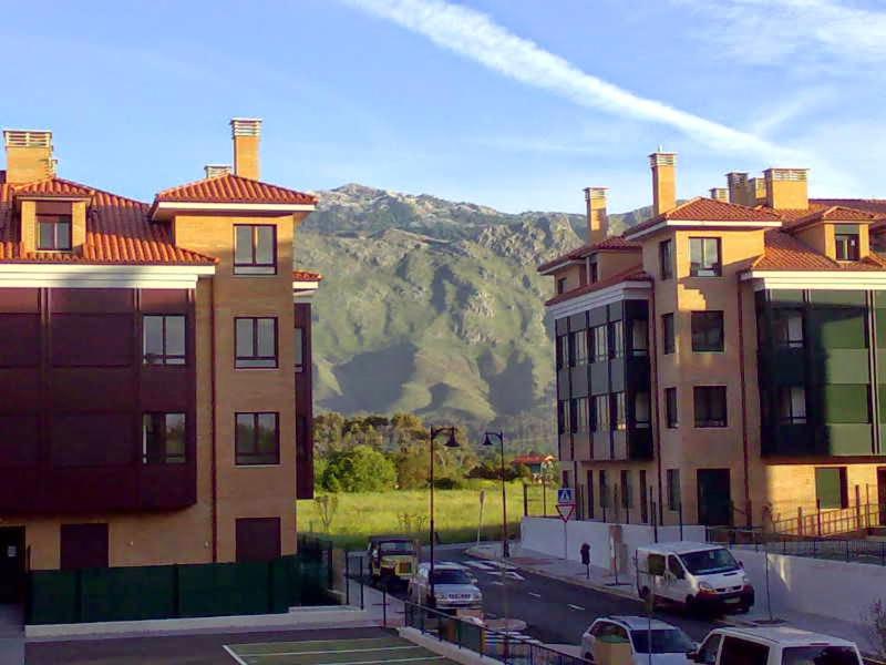 a group of buildings with mountains in the background at Apartamento Llanes Mar y Monte in Llanes