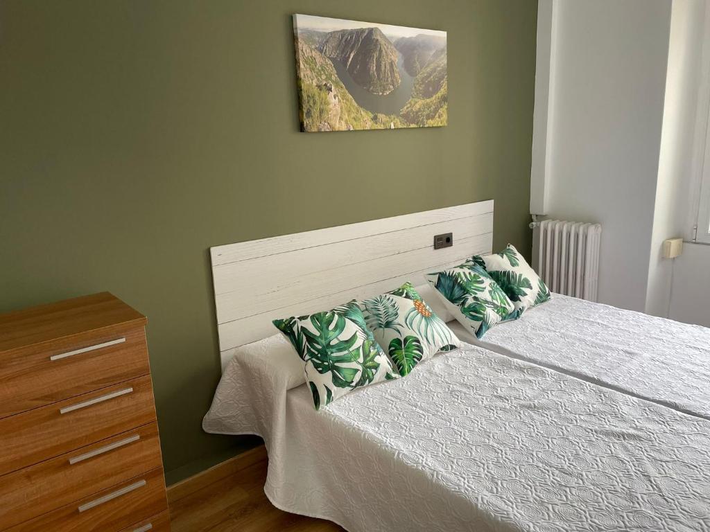 - une chambre avec un lit et une photo sur le mur dans l'établissement Albareda piso super-céntrico en Sarria, à Sarria