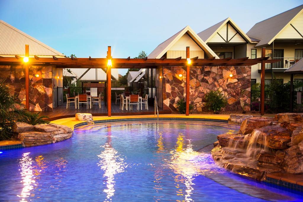 a swimming pool with a waterfall in a house at Freshwater East Kimberley Apartments in Kununurra