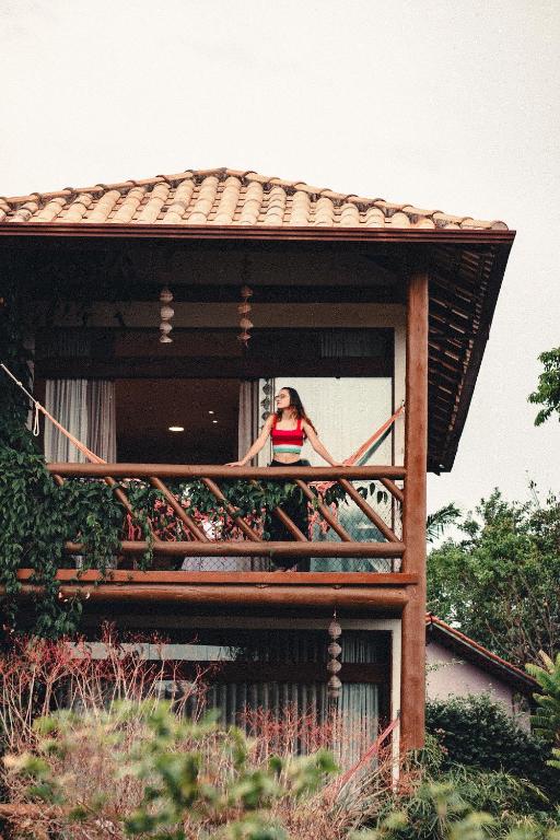 a woman standing on a balcony of a house at Pousada Meu Talento in Alto Paraíso de Goiás