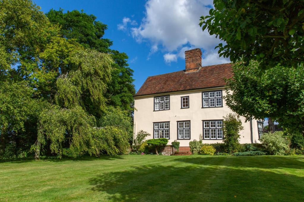 a large white house with a large yard at Pounce Hall -Stunning historic home in rural Essex in Saffron Walden