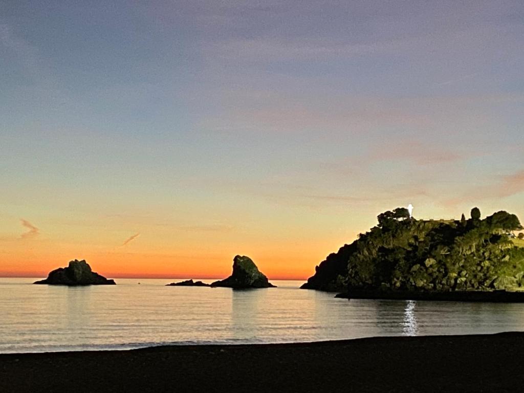 plaża z kamieniami w wodzie o zachodzie słońca w obiekcie arte junto al mar w Almuñécar