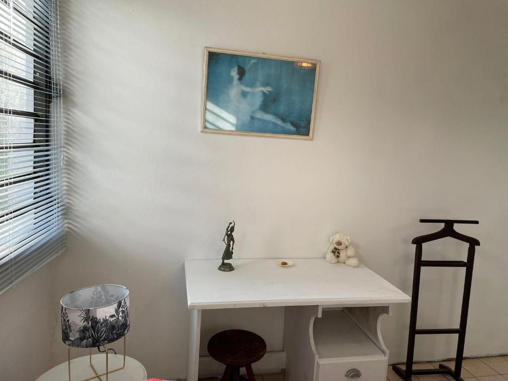 La salle de bains est pourvue d'un lavabo et d'une photo murale. dans l'établissement A&J Cottage, à Le Morne Rouge