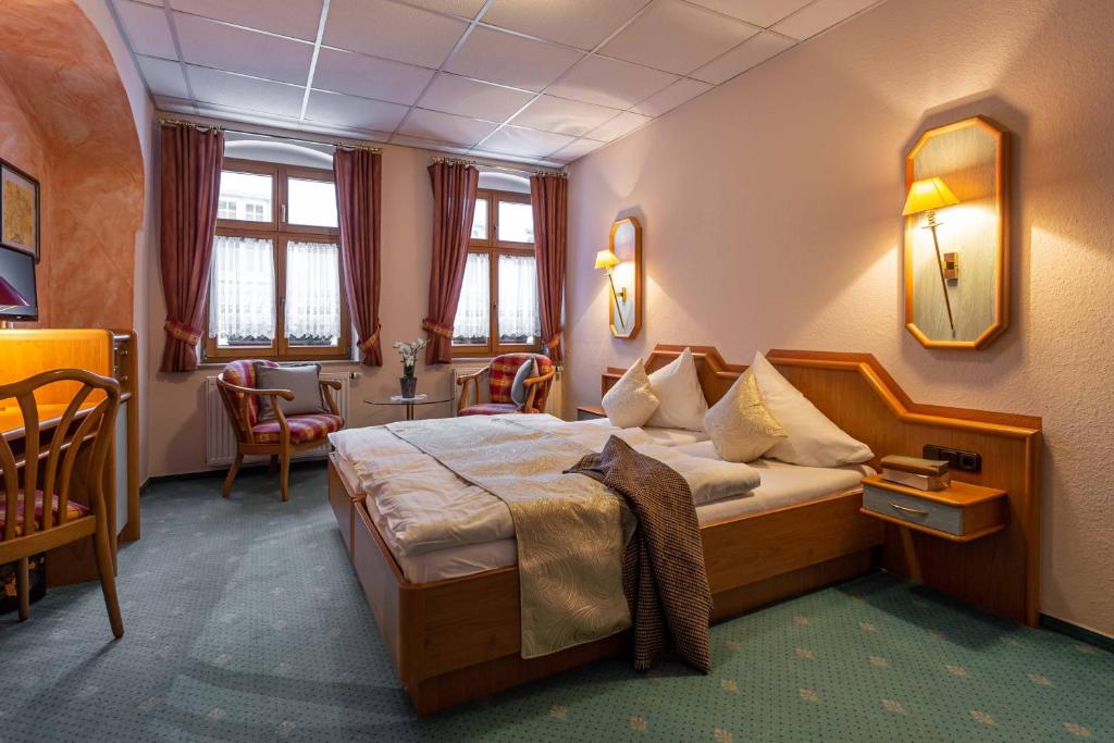 a hotel room with a bed and a table and chairs at Das Büttner in Schneeberg