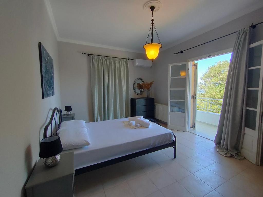 Villa Southern Comfort في ليفكيمي: غرفة نوم بسرير ونافذة كبيرة