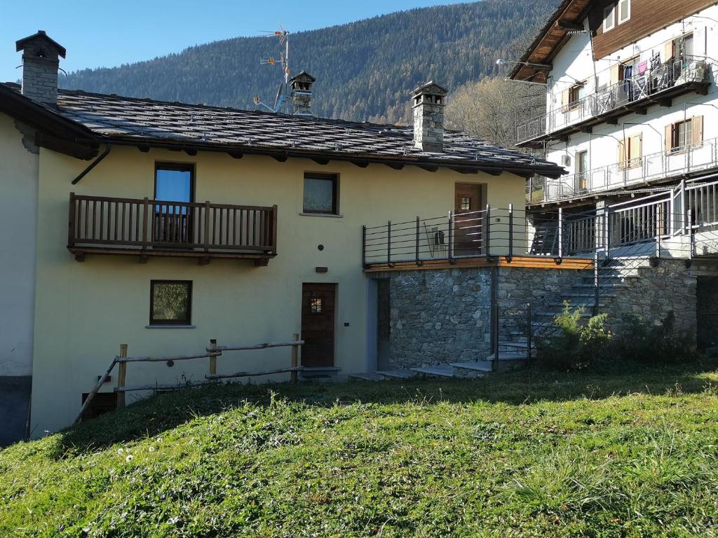 una casa con un balcón en el lateral. en Accogliente e confortevole appartamento a Doues, en Doues