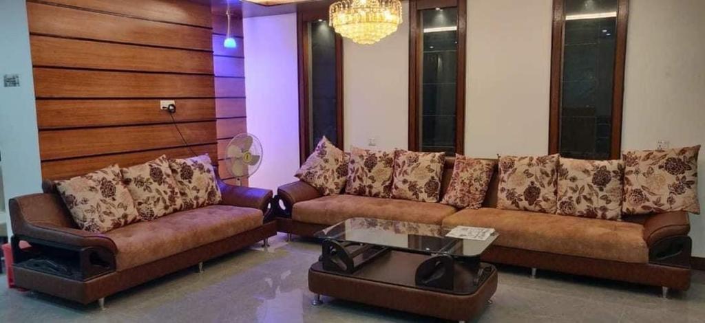 uma sala de estar com dois sofás e uma mesa em Hotel Opera Ocean em Cox's Bazar