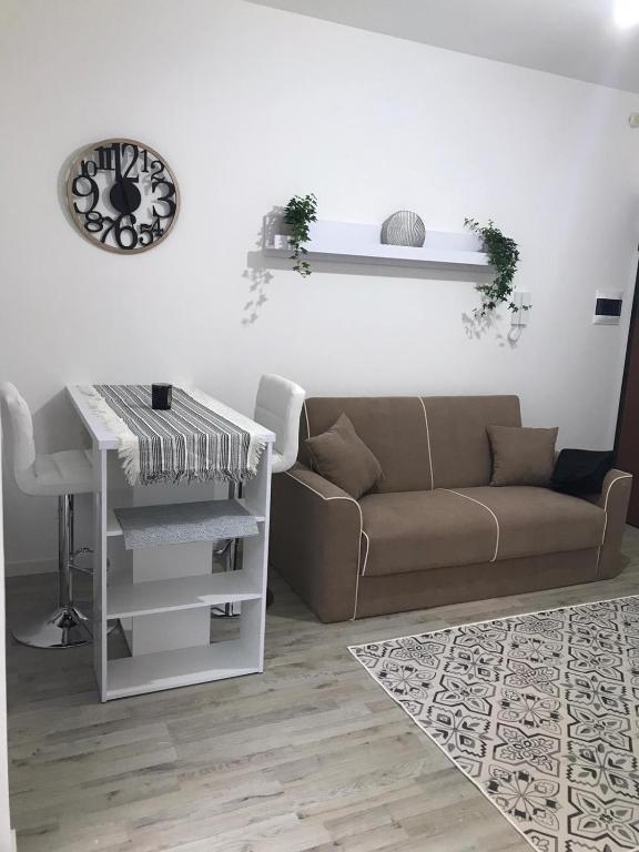 uma sala de estar com um sofá e uma mesa em Mini Comfort House Udine em Udine