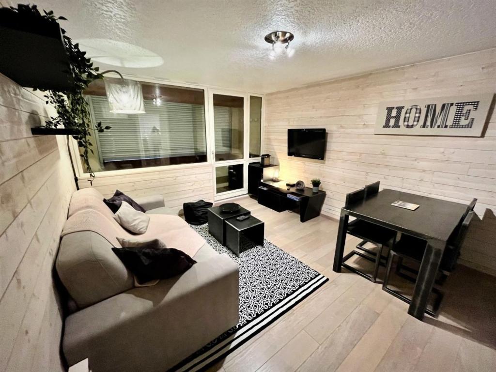 un salon avec un canapé et une table dans l'établissement Location appartement saint lary 2/4 personnes, à Saint-Lary-Soulan