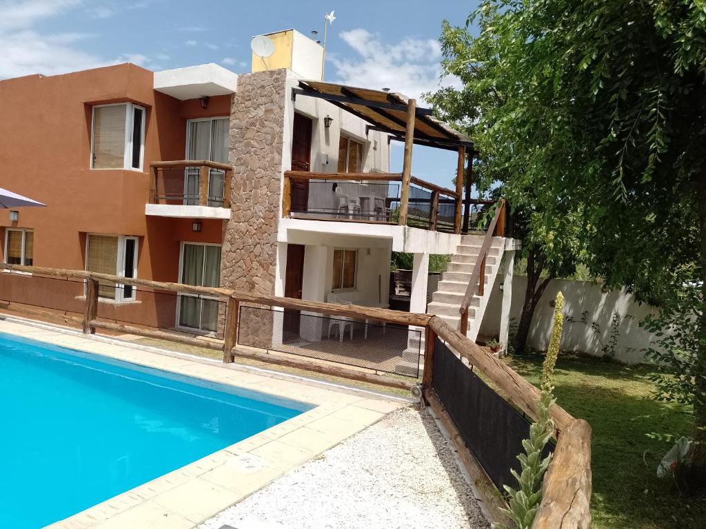 una villa con piscina frente a una casa en Cerro Encanto, en Potrero de los Funes