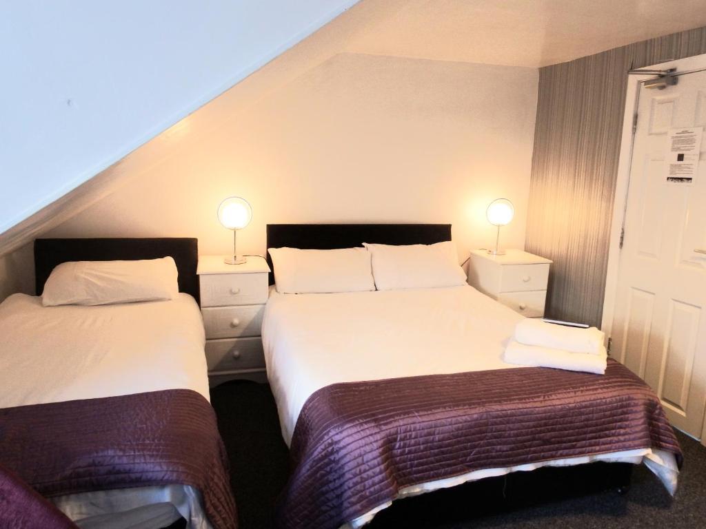 a hotel room with two beds and two lamps at Idan House in Llanberis