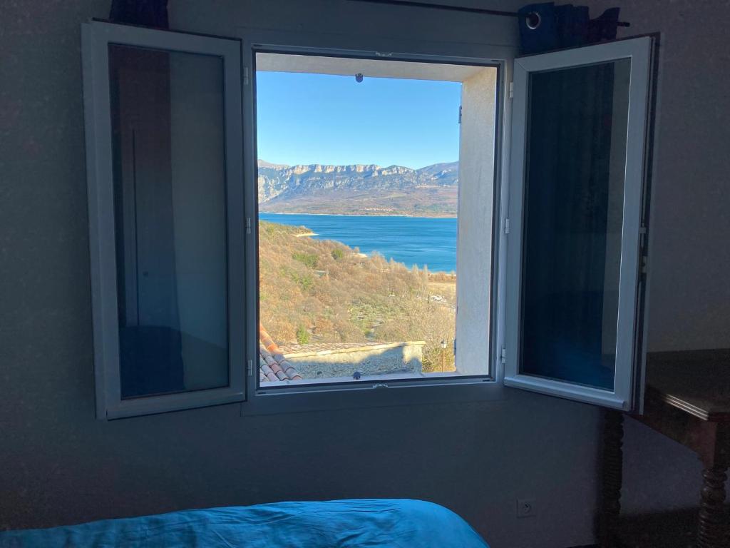 a window in a bedroom with a view of the ocean at Perle rare in Sainte-Croix-de-Verdon
