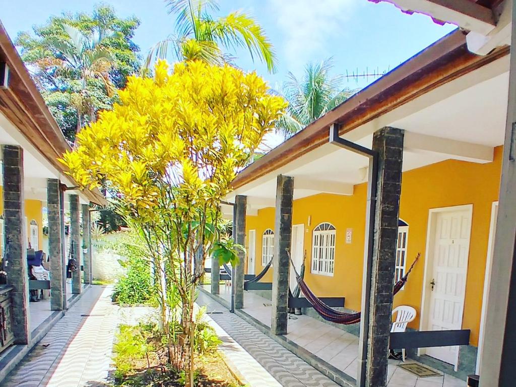 a yellow house with a hammock in the courtyard at Pousada Vila do Sonho in Paraty