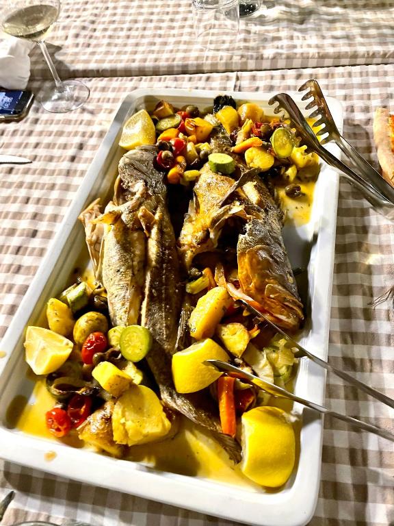 a plate of food with fish and vegetables on a table at ELMAR HOTEL in Vlorë