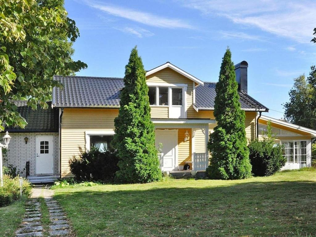 una casa con dos árboles delante de ella en 6 person holiday home in MELLERUD, en Mellerud