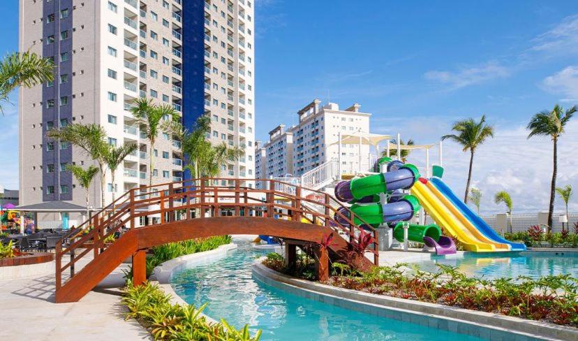 une aire de jeux avec un pont au-dessus d'une piscine avec un toboggan dans l'établissement Salinas Exclusive Resort, à Salinópolis