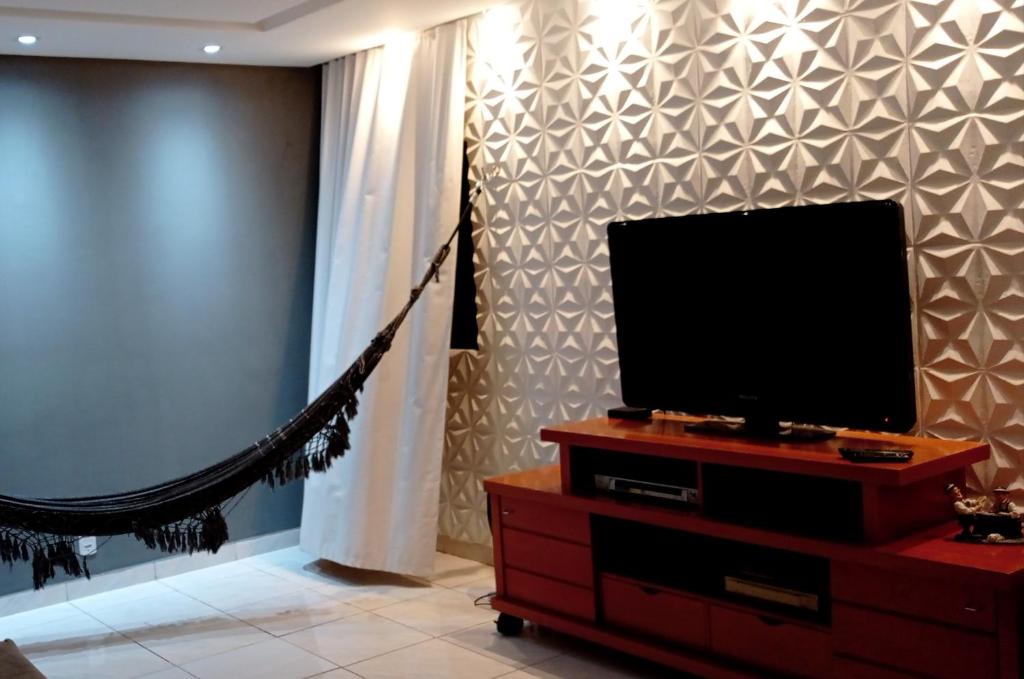 ein Wohnzimmer mit einem Flachbild-TV auf einer Kommode in der Unterkunft Apto Olinda Casa Caiada ao lado do Shopping in Olinda