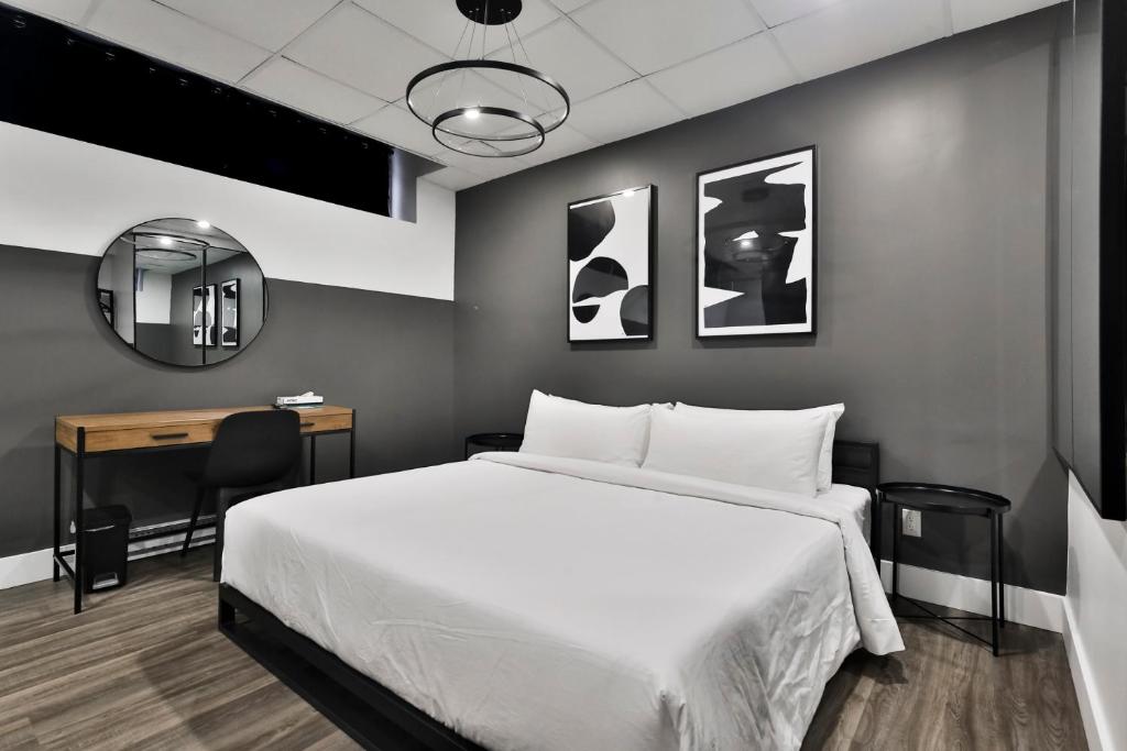a bedroom with a bed and a desk and a mirror at Hygie Boutique Hotel in Montreal