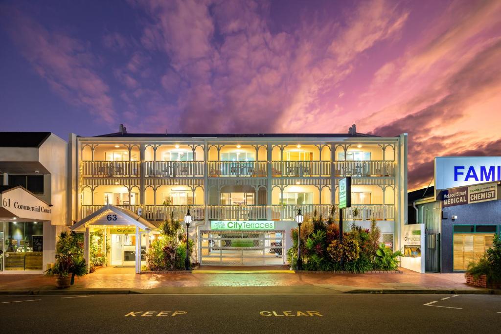 um grande edifício com luzes acesas à noite em City Terraces Cairns em Cairns