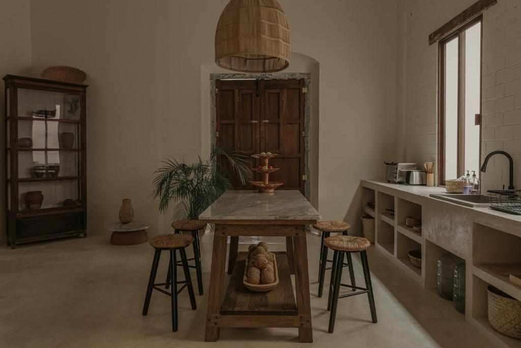 een keuken met een tafel en stoelen in een kamer bij Narrativ Lofts -Solario- Charming Historic Escape in Campeche