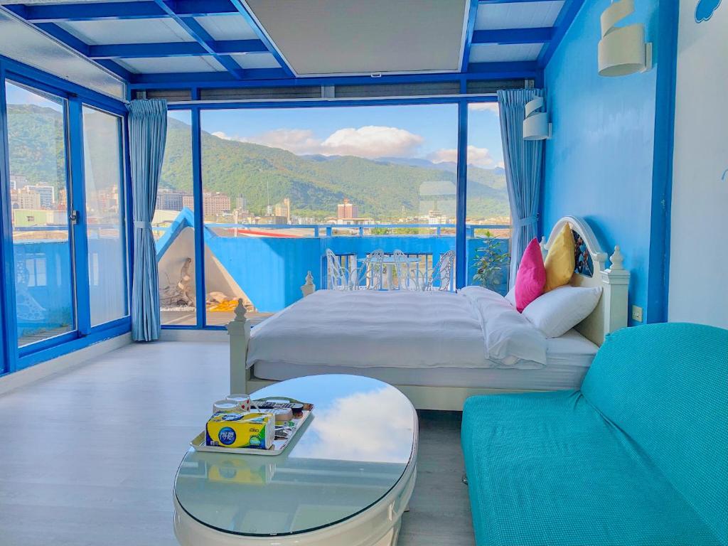 een slaapkamer met een bed en een groot raam bij Chiaohsi Mediterranean Spa B&B in Jiaoxi