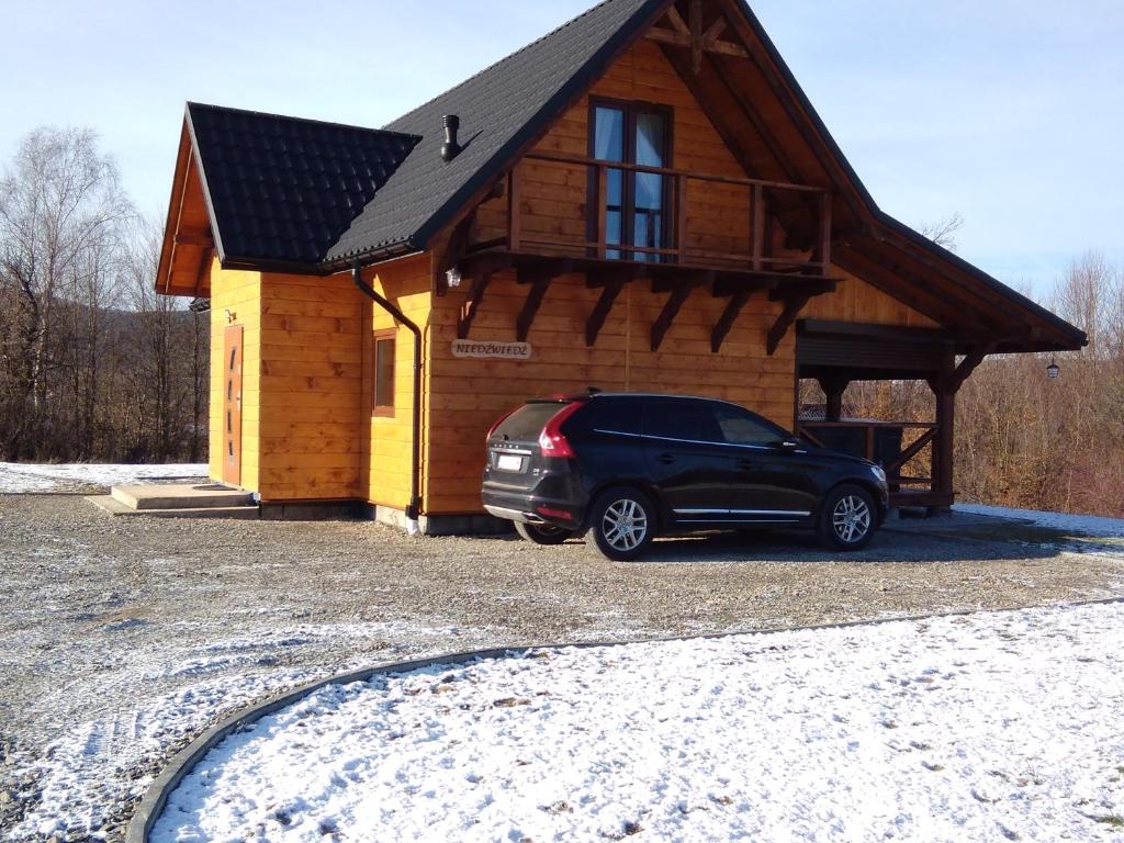 samochód zaparkowany przed małym domem w obiekcie Domek na wzgórzu ''NIEDŹWIEDŹ'' w mieście Świątkowa Mała