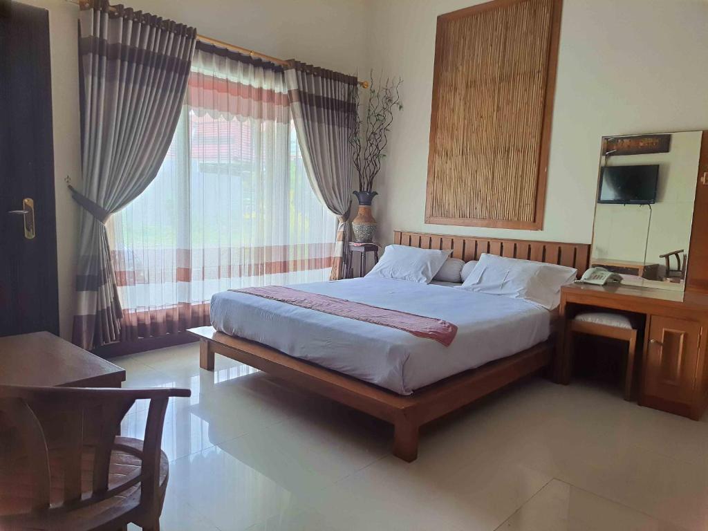 um quarto com uma cama grande e uma janela em Omahkoe Syariah Guesthouse RedPartner em Seturan