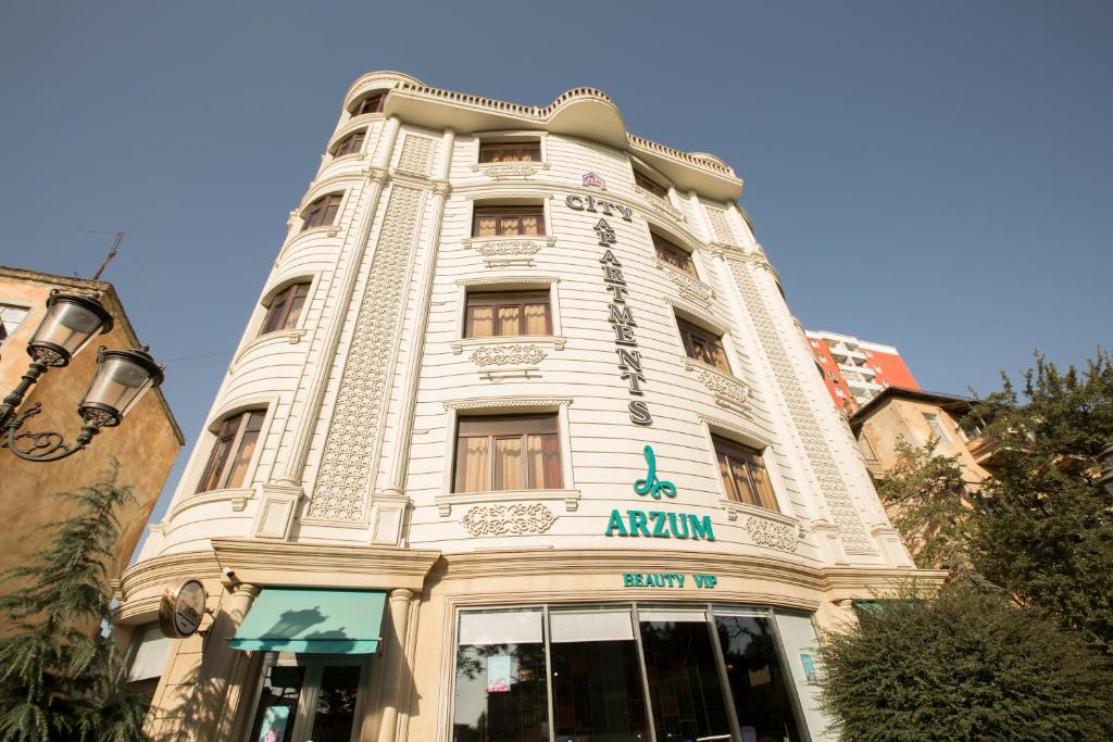 un grand bâtiment blanc avec un panneau sur celui-ci dans l'établissement City Apartments, à Baku