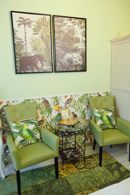a living room with two chairs and a table at Anno 1900 Hotel Babelsberg in Potsdam