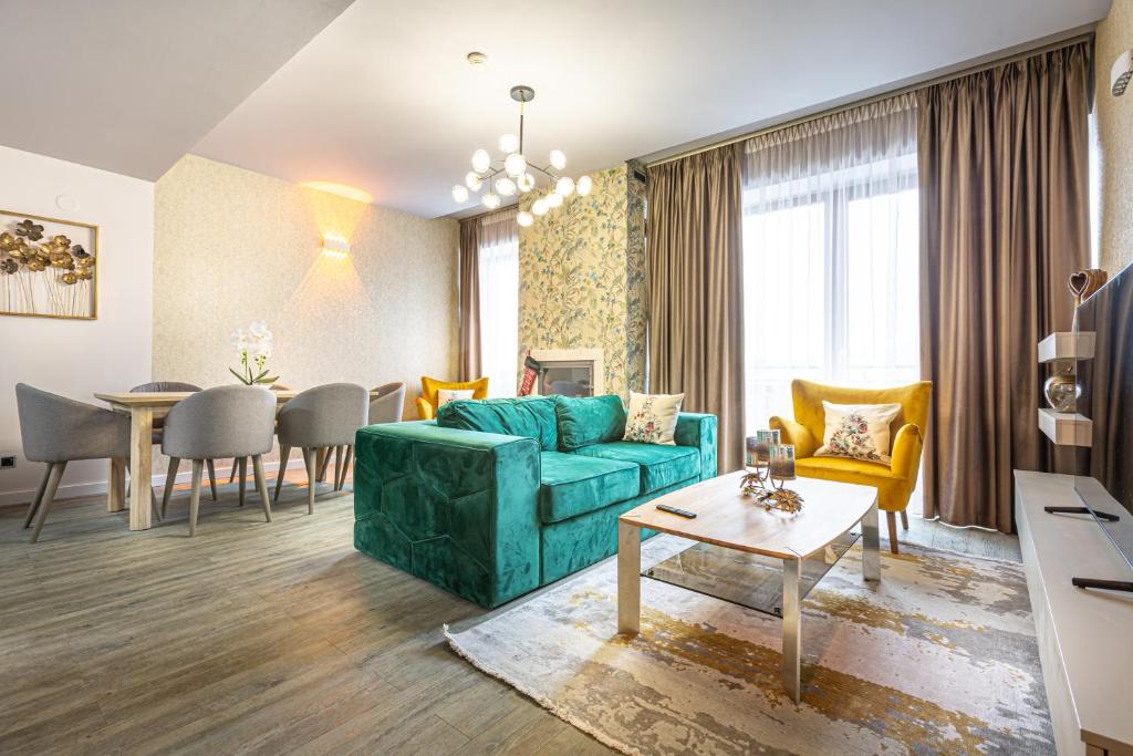 Kron luxury 2 Bedroom Apartment in Silver Mountain في بويانا براسوف: غرفة معيشة مع أريكة خضراء وطاولة