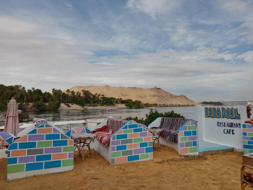 een groep parasols en stoelen op een strand bij Baba Dool in Aswan