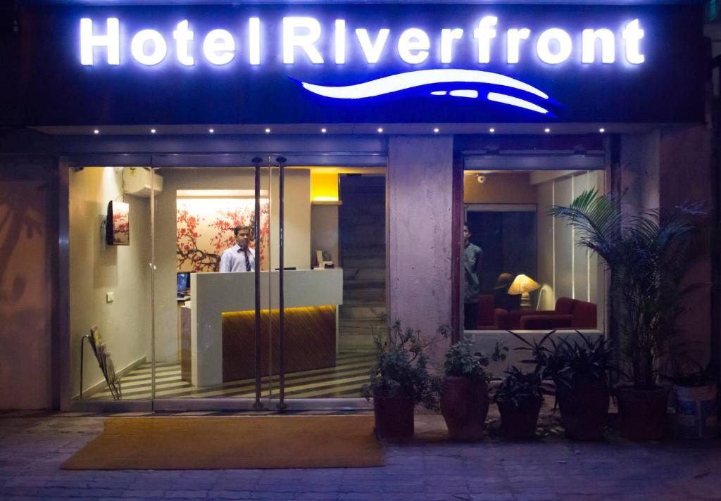 un cartello di hotelyrmont di fronte a un edificio di notte di Hotel Riverfront a Ahmedabad