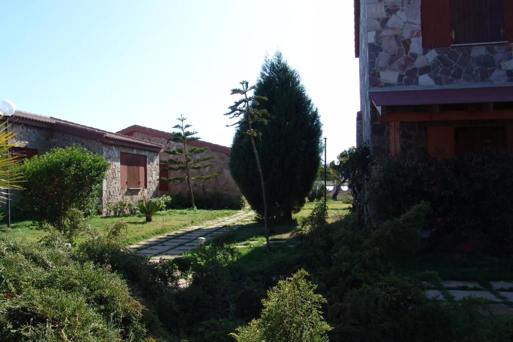 a garden with a tree next to a building at Il Gabbiano in Chia