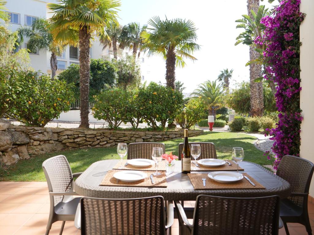 a table with plates and wine glasses on a patio at Spacious Apartment near Porto de Mos Beach, Lagos. in Lagos