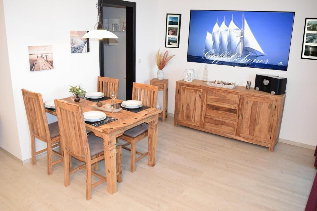 ein Esszimmer mit einem Holztisch und Stühlen in der Unterkunft Ferienwohnung Gaffelschoner in Hohen Wieschendorf