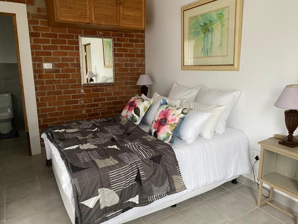 a bedroom with a bed and a brick wall at Twin peaks in Underberg
