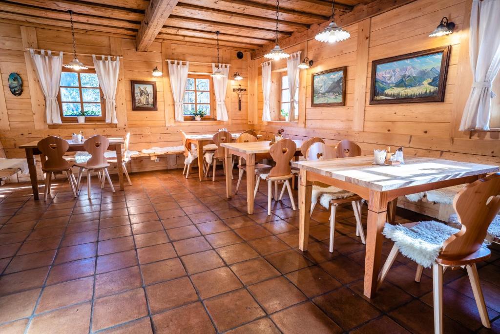 a dining room with wooden tables and chairs at Tourist Farm Šenkova Domačija in Zgornje Jezersko