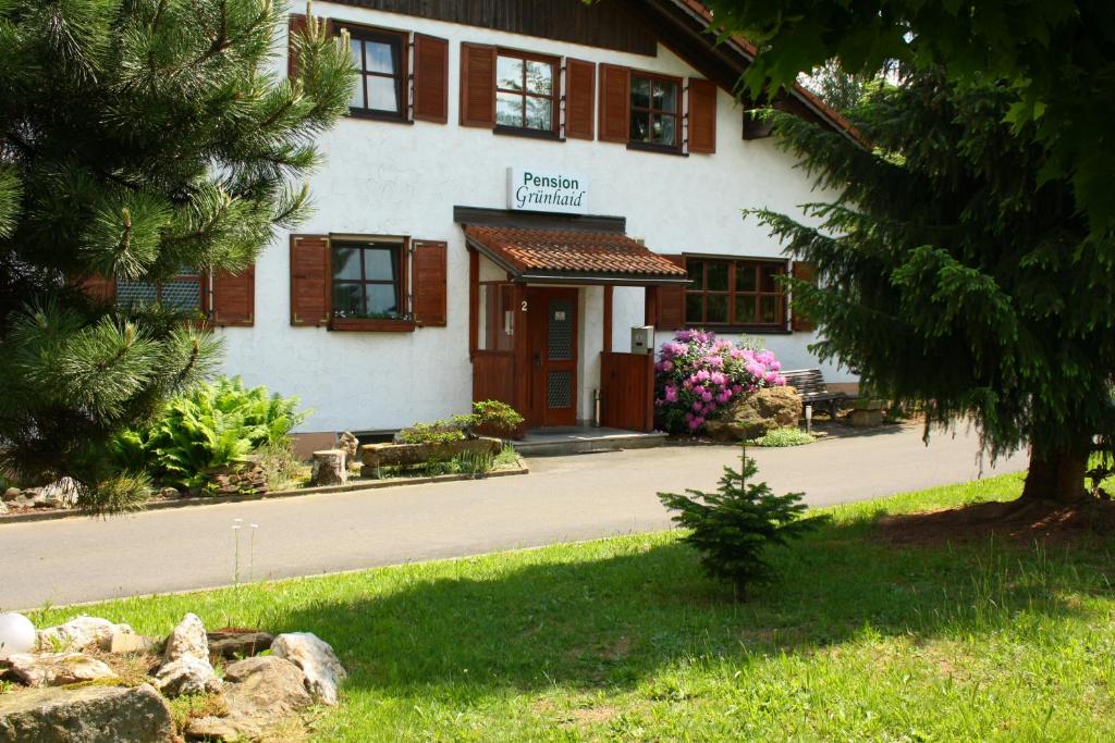 a building with a tree in front of it at Pension Grünhaid in Schönwald