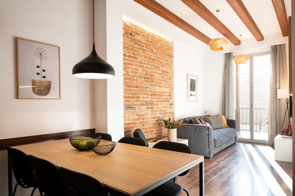 ein Wohnzimmer mit einem Holztisch und Stühlen in der Unterkunft Aspasios Market Balconies in Barcelona