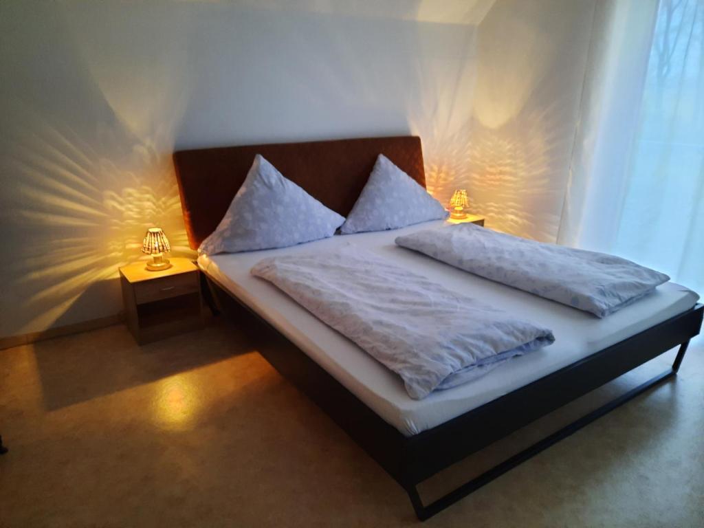 ein Schlafzimmer mit einem Bett mit zwei Lampen in der Unterkunft Ferienwohnungen Burger Nachtigall in Burg
