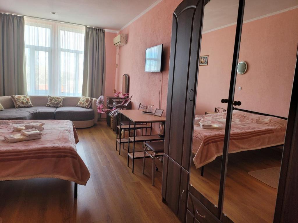 a hotel room with two beds and a couch at Vodnyi Mir in Bilhorod-Dnistrovsʼkyy