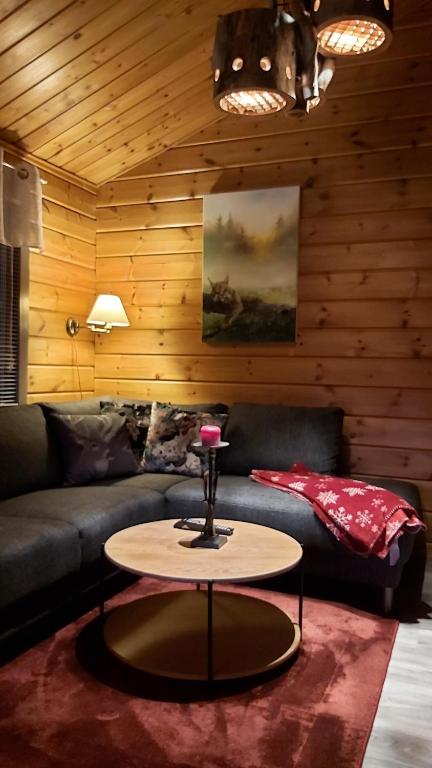un salon avec un canapé et une table dans l'établissement Vuosselin Tähti, à Ruka
