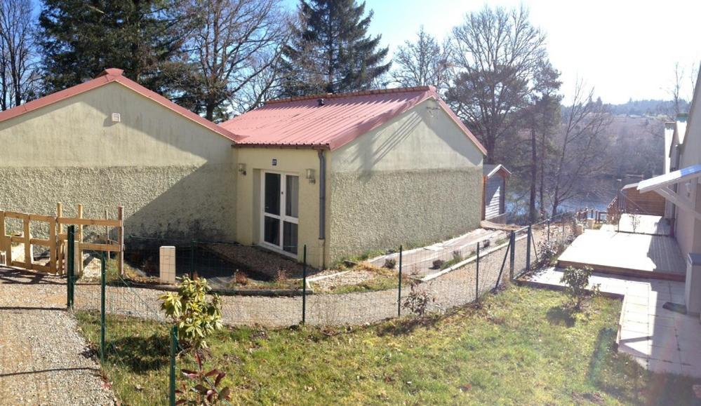 een klein huis met een hek ervoor bij Osez la Creuse - Au bord du lac de Vassivière - 27 in Royère-de-Vassivière